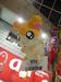 A large Hamtaro figure hangs in the shopping plaza advertising a store.