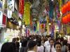 People, some enjoying the festival and some trying to get home from work, make their way through the main walkway of the tanabata festival.