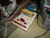 A close-up of the Famicom with Super Mario Brothers 3 inside.  Famicom cartridges are technically similar to NES carts, but have a smaller size and are more colorful.